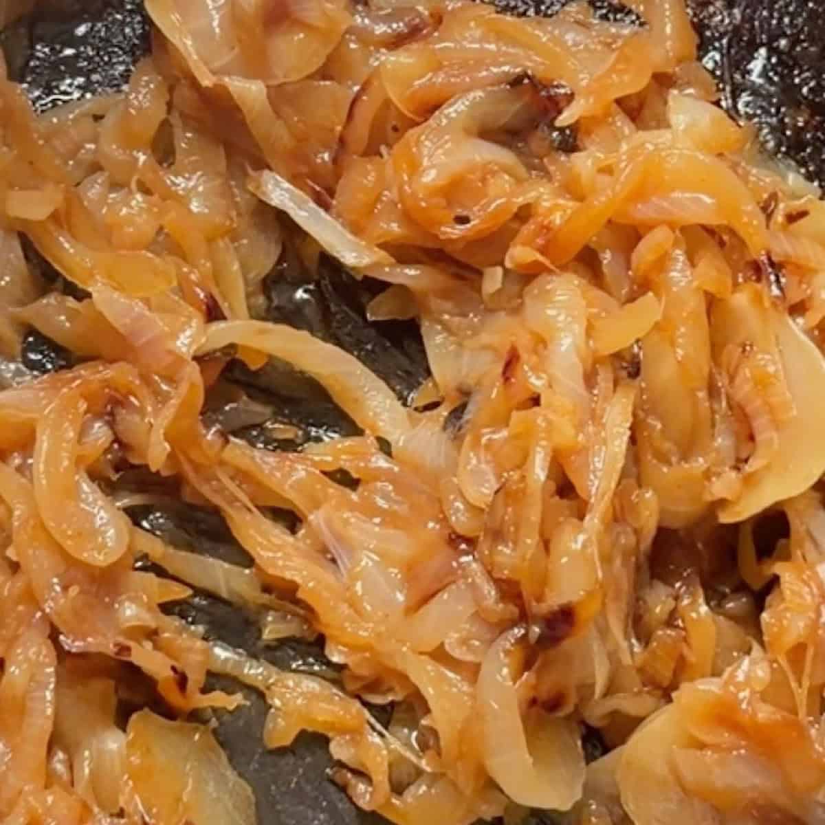 Stirring seasoning into the deeply browned caramelized onions.