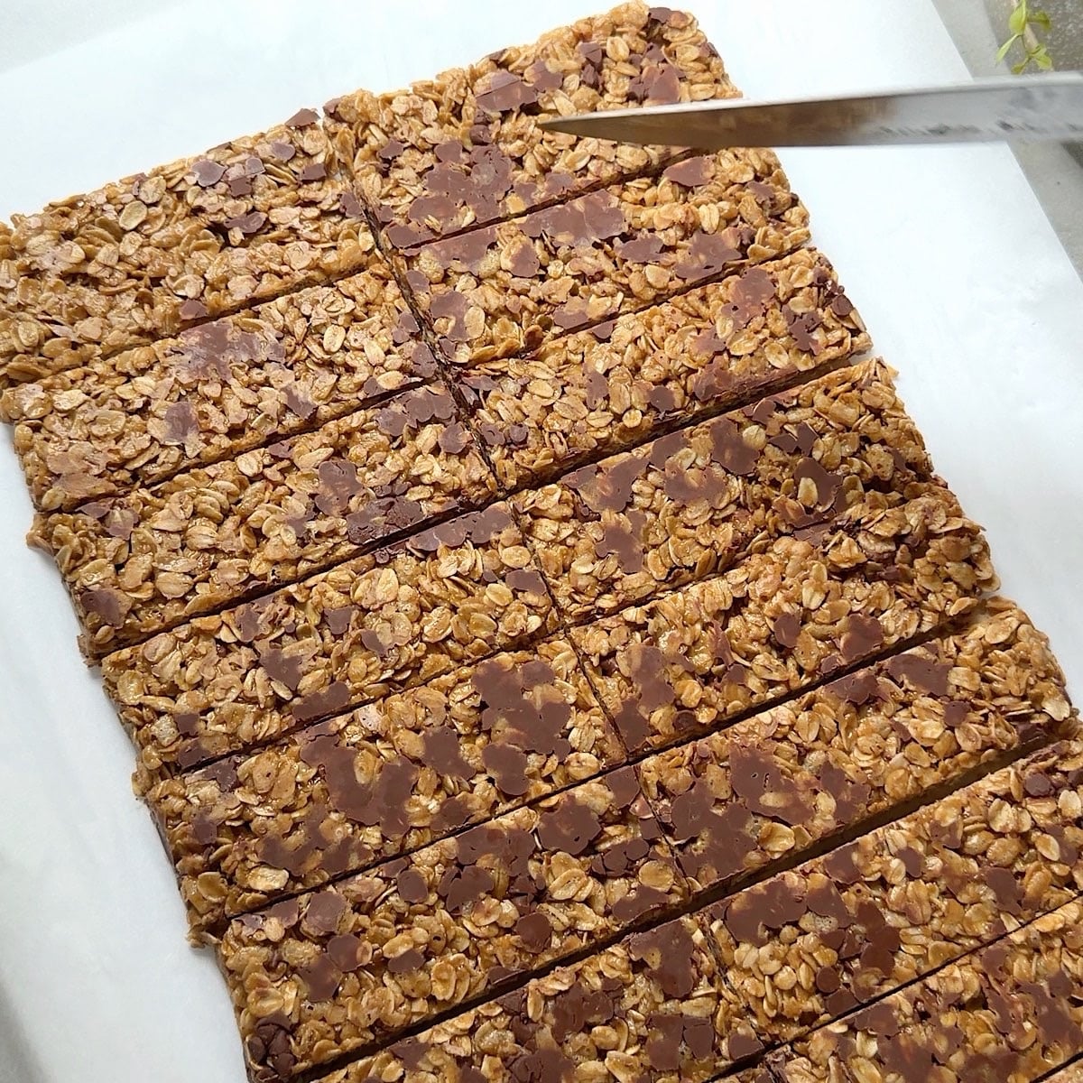 Slicing peanut butter granola bars into long rectangles.