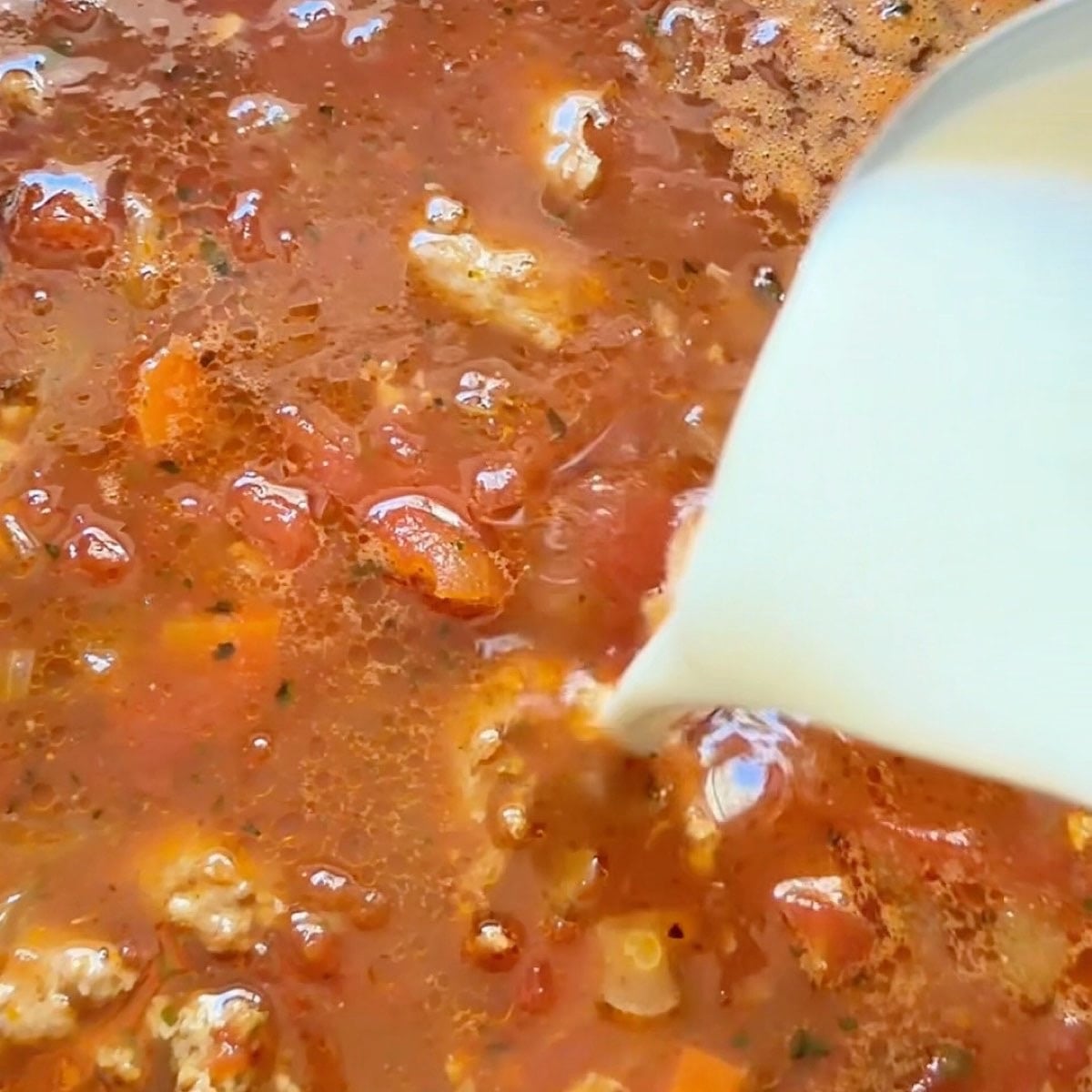 Adding garlic and tomato paste to the deglazed vegetables with white wine.