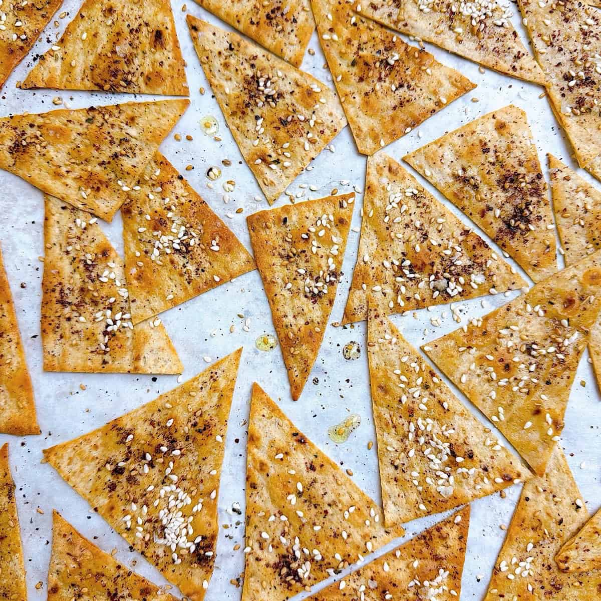 Baked la'vash crackers with storebought bread showing crispy brown edges.