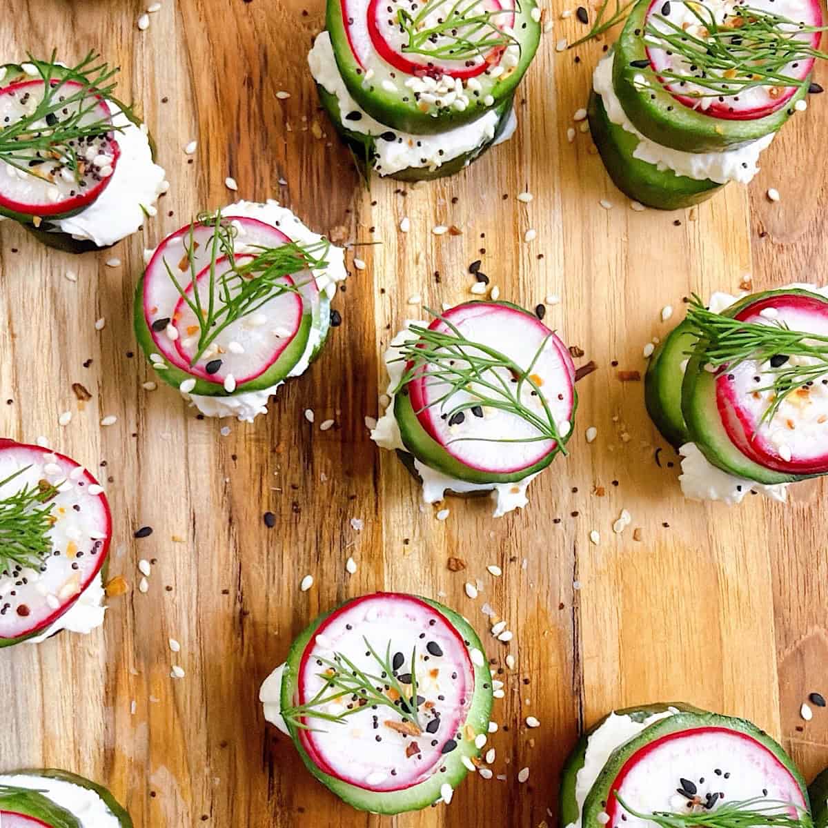 Garnished cucumber bites with cream cheese, radish, Everything bagel seasoning, and dill.