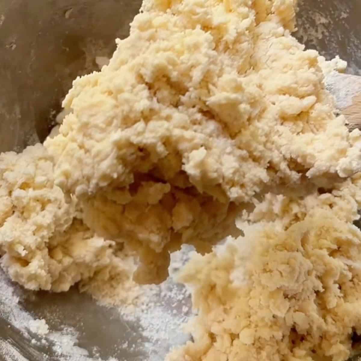 A spoon holding the soft shaggy biscuit dough topping.