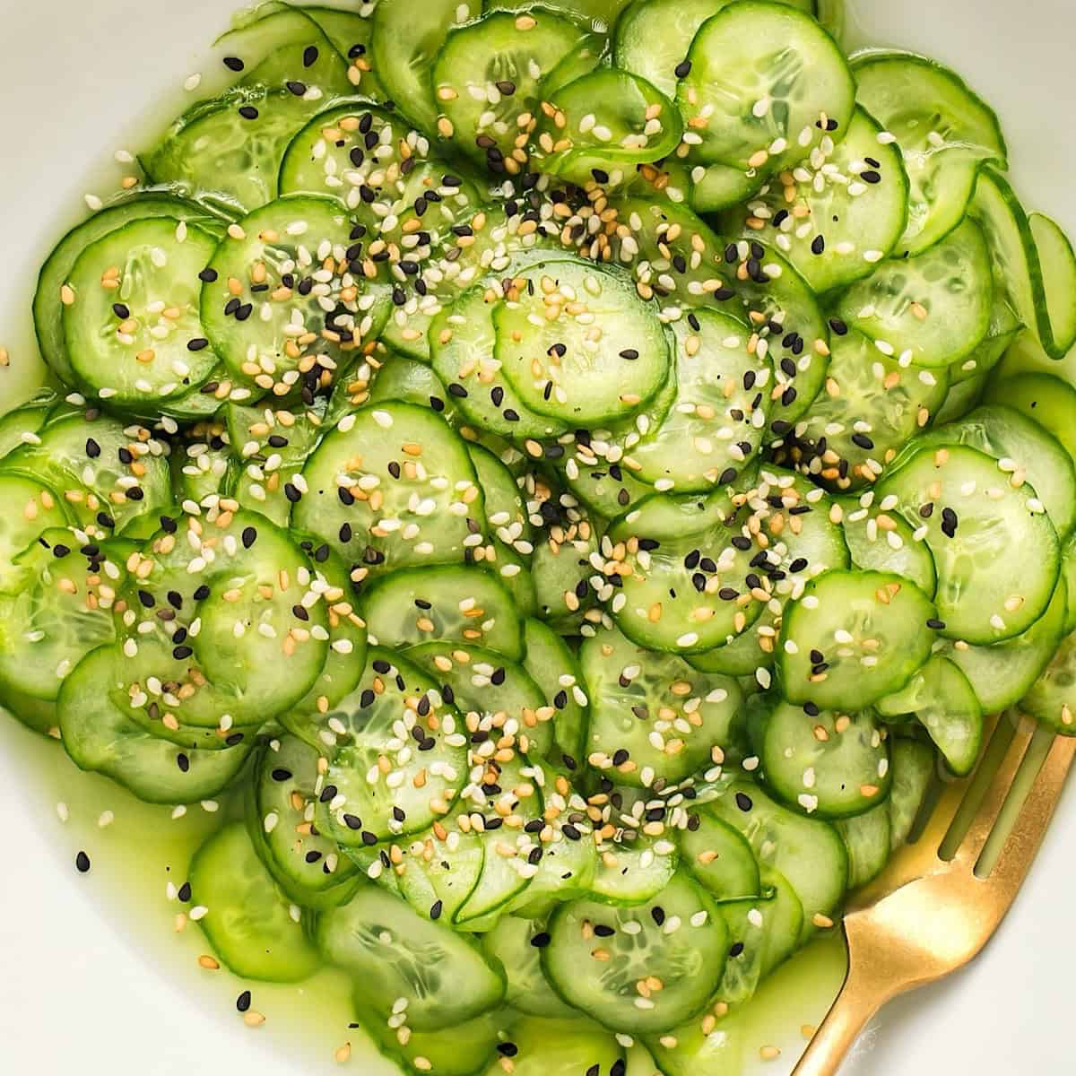 Sunomono salad with gold utensil.