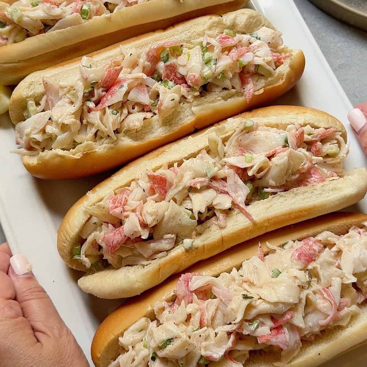 Holding a platter of crab salad sandwiches
