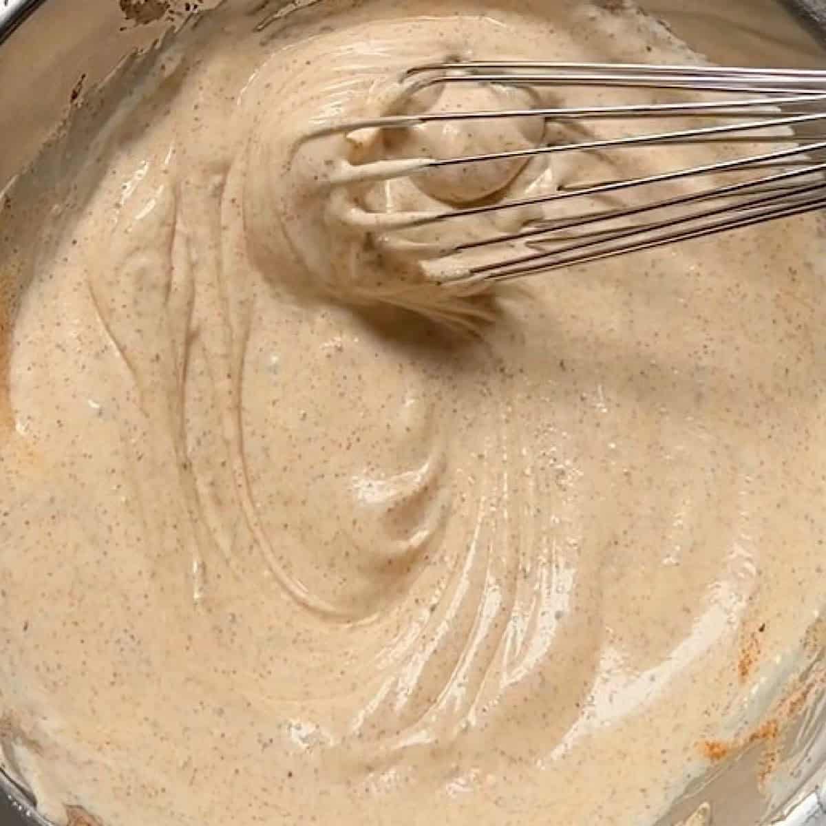 Whisking together the mayonnaise based crab salad sandwich dressing.