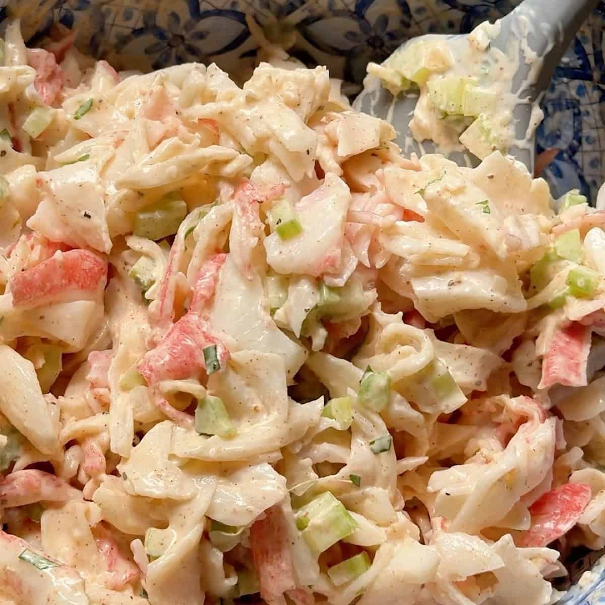 Gently folding the imitation crab meat, celery, and onion with dressing and seasoning.