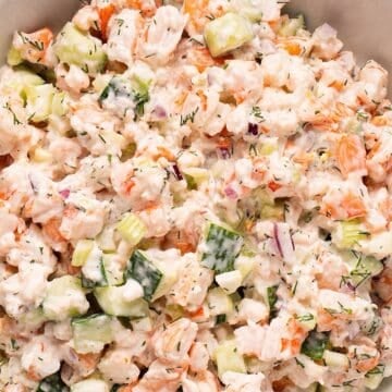 Creamy cucumber shrimp salad in a white bowl.