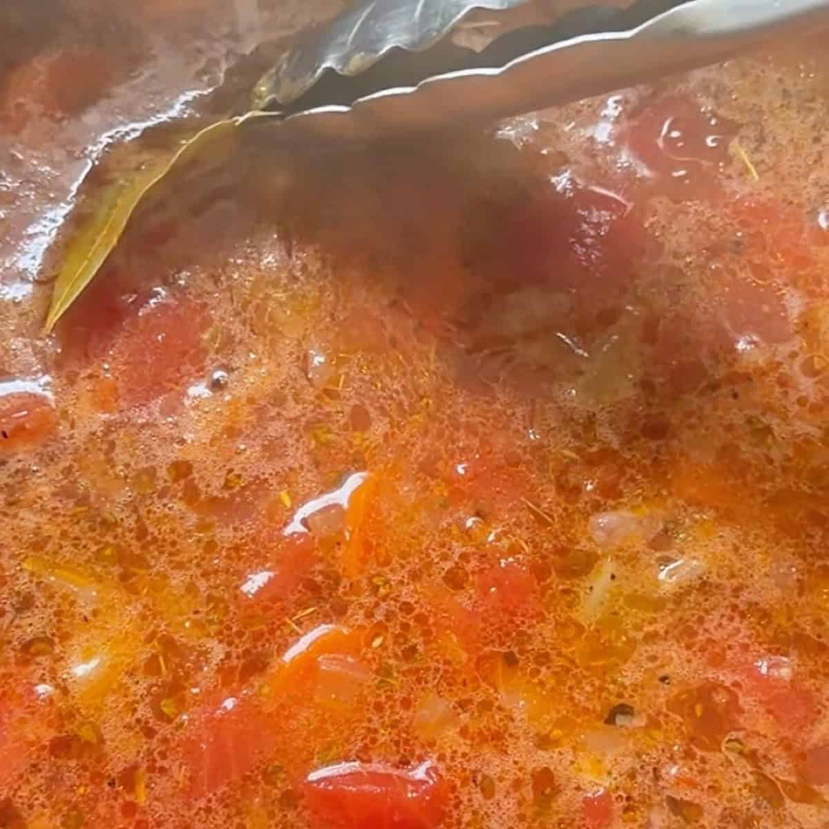 Removing the bay leaves from the fasolada soup.