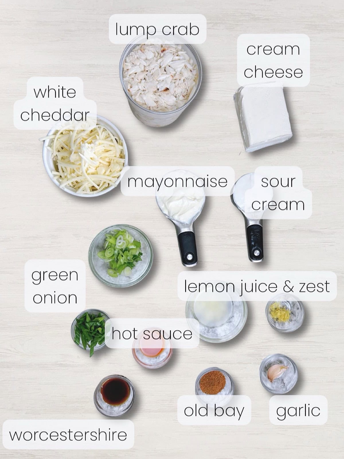 A labeled image of all the ingredients needed to make baked hot crab dip with cream cheese.