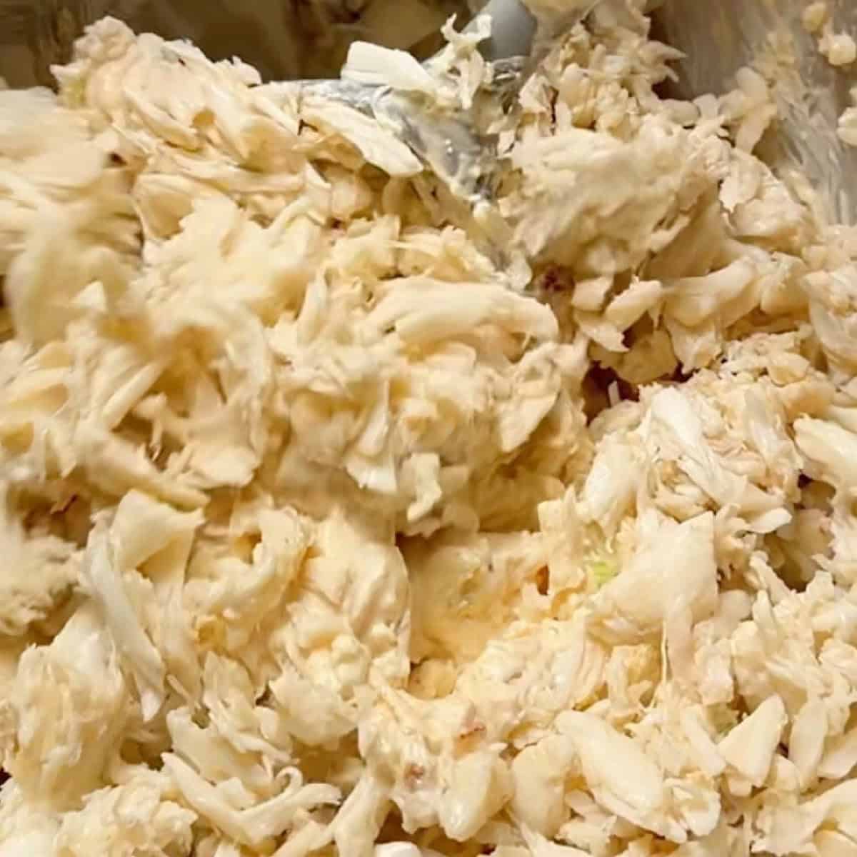Gently folding in the lump crab meat to the creamy base.