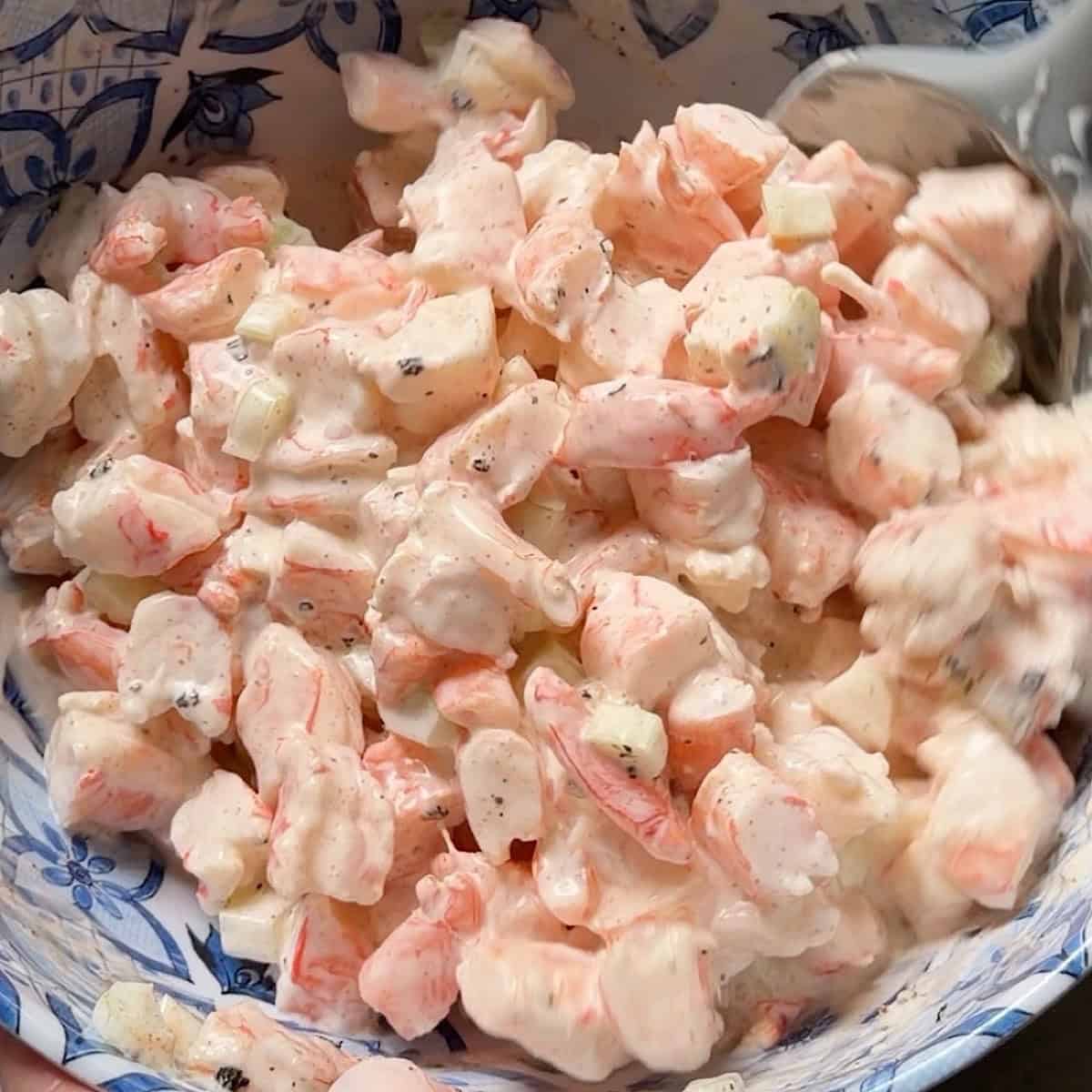 Folding the shrimp into the creamy dressing ingredients.