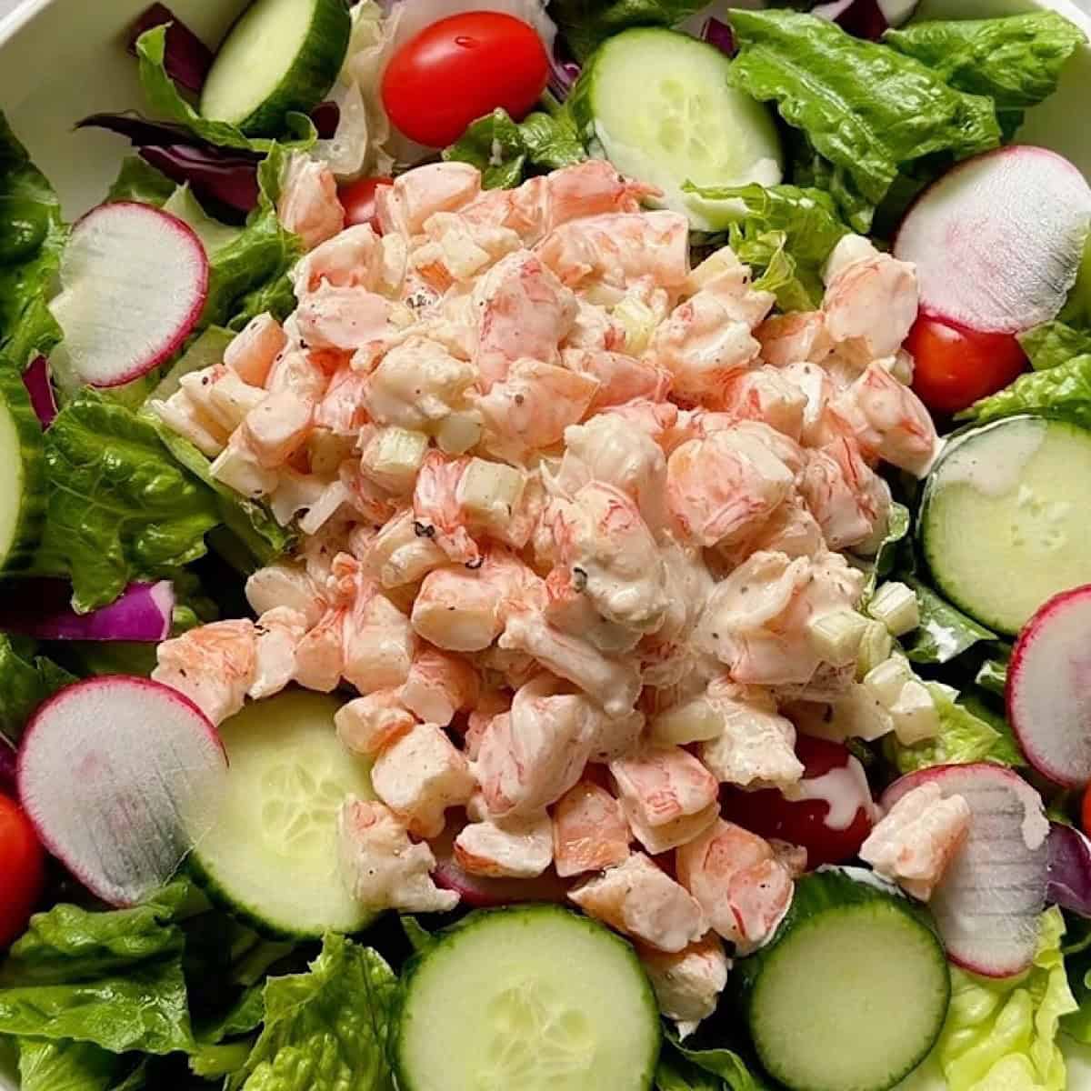 Old Bay shrimp salad resting on top of greens.
