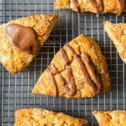 Apple cinnamon scones with maple glaze on a wire rack.