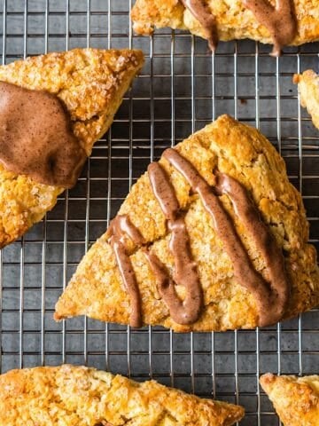 Apple cinnamon scones with maple glaze on a wire rack.