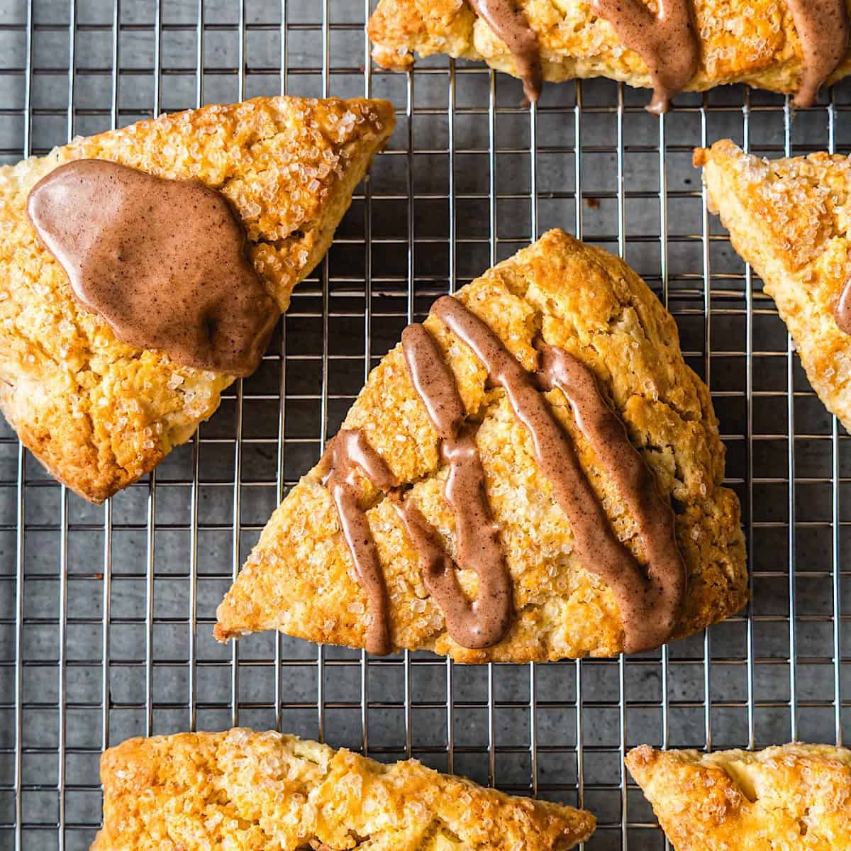 Apple cinnamon scones with maple glaze on a wire rack.