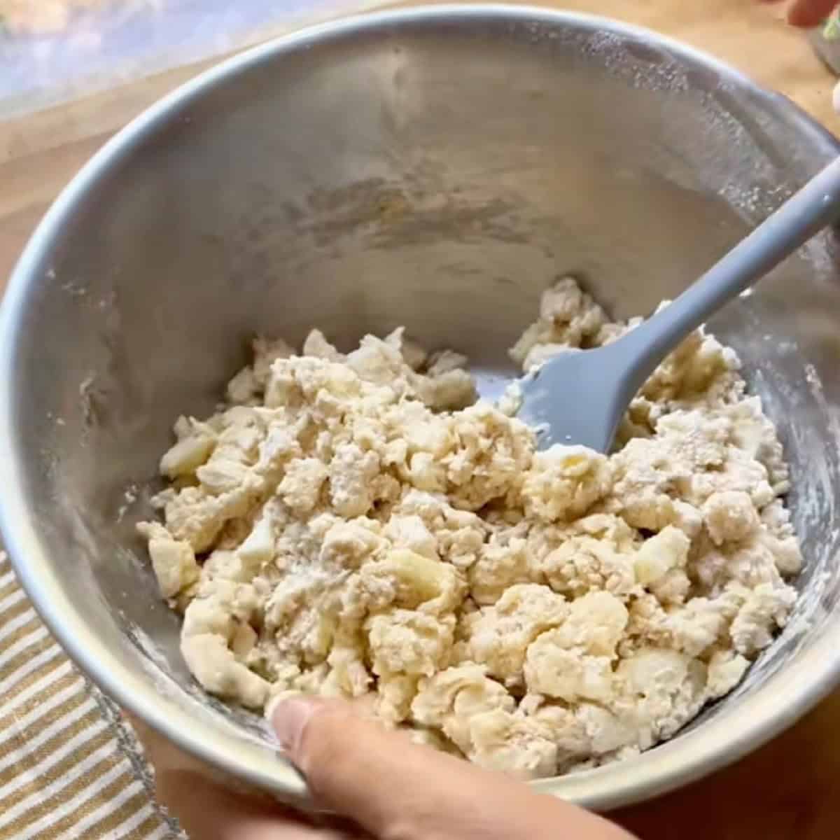 Forming the shaggy dough by mixing dry and wet ingredients.