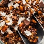 A scoop of dark chocolate coconut granola with visible coconut flakes and chocolate chunks.