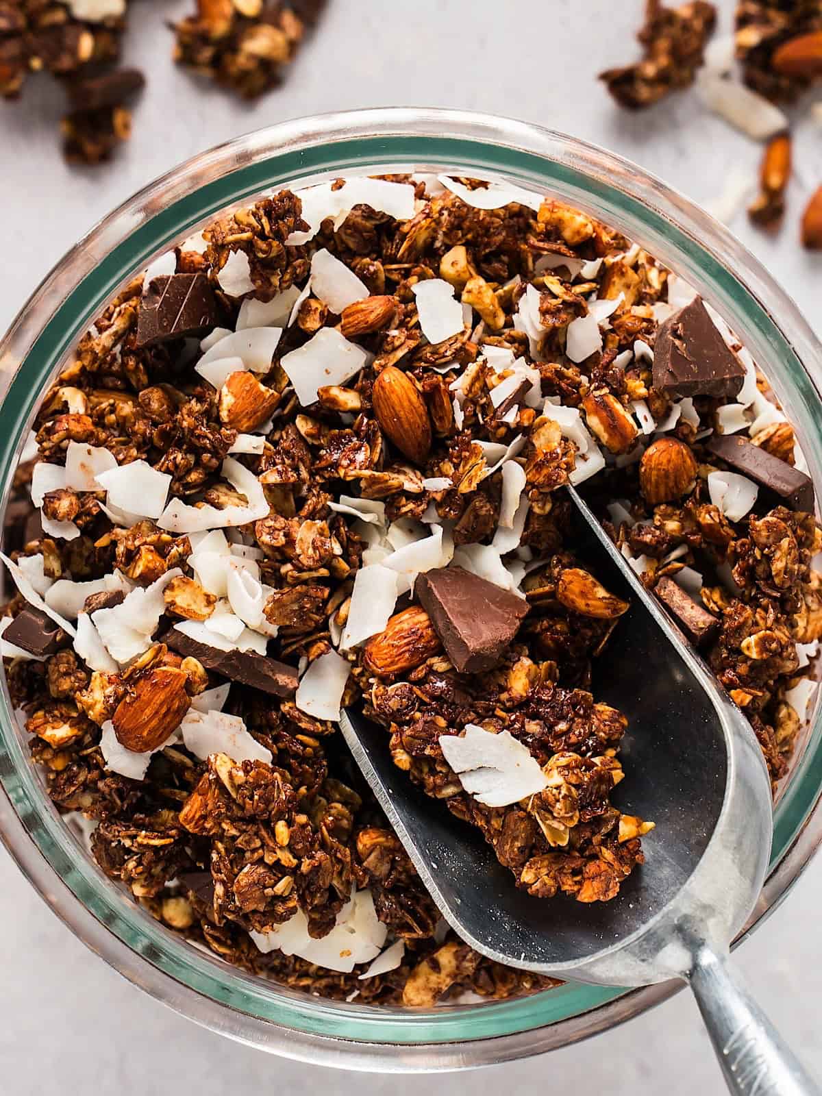 A jar of dark chocolate granola with coconut flakes and dark chocolate chunks.