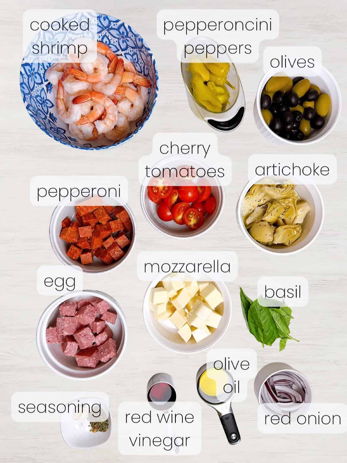 A labeled image of every ingredient needed to make an Italian shrimp antipasto salad.