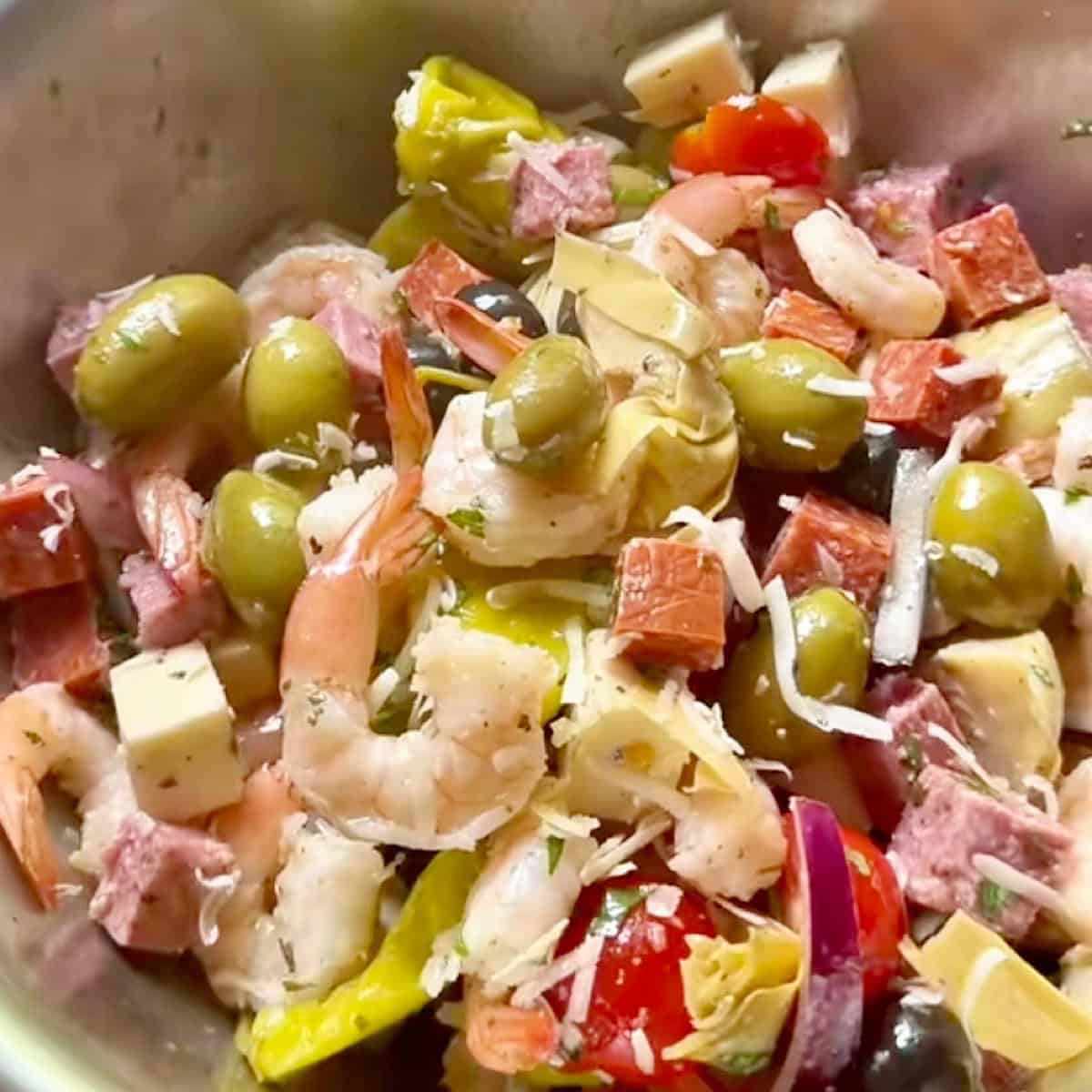 Shrimp antipasto salad tossed with dressing.