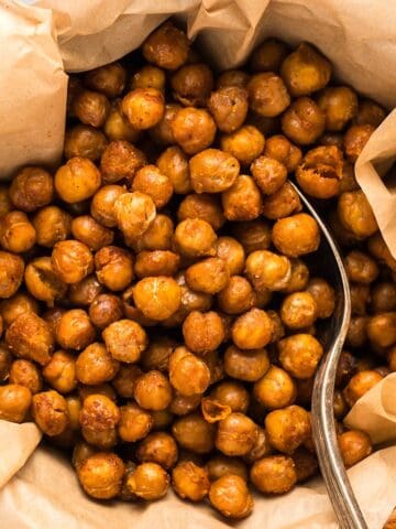 Crispy buffalo chickpeas in a parchment lined wooden bowl.
