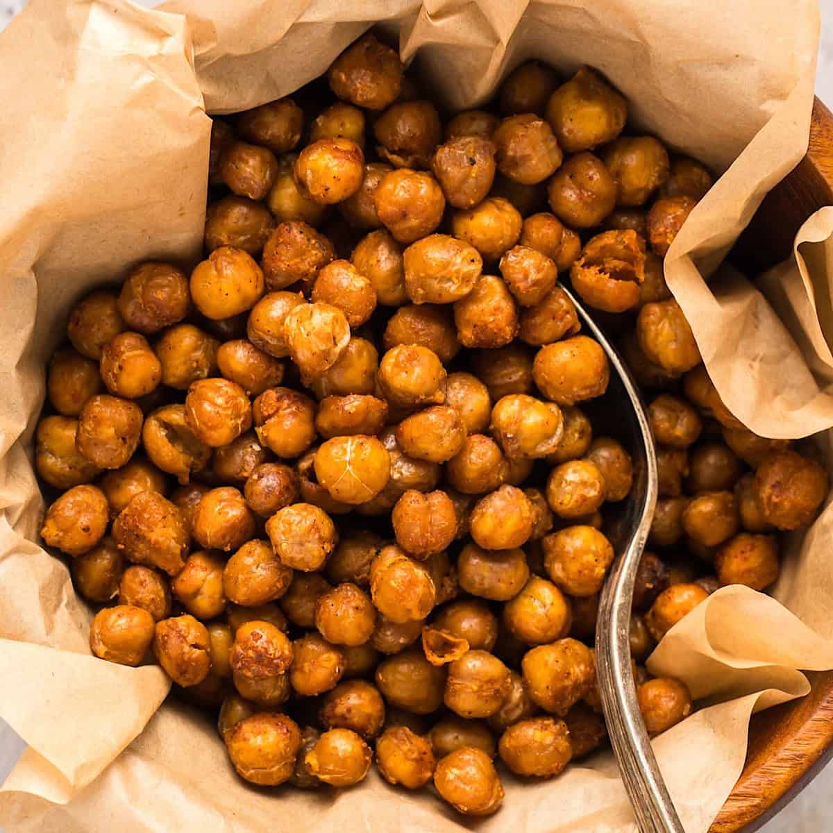 Crispy buffalo chickpeas in a parchment lined wooden bowl.