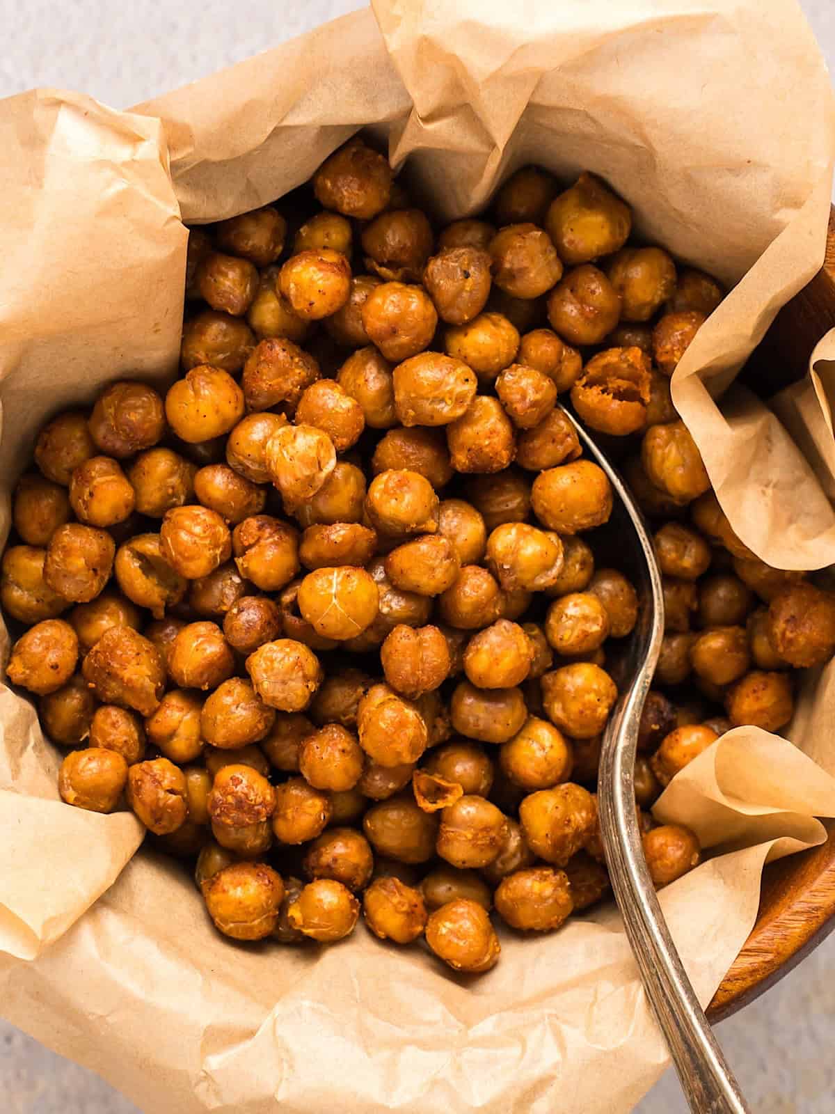 Crispy buffalo chickpeas in a parchment lined wooden bowl.