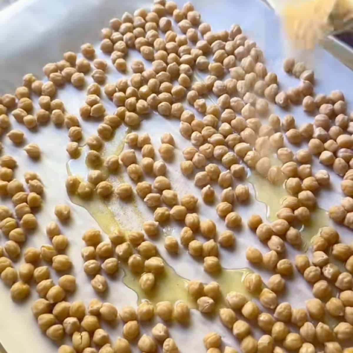 Seasoning the chickpeas before roasting.