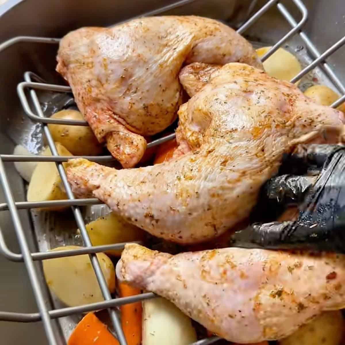 Chicken leg quarters and vegetables rubbed with oil and seasoning.