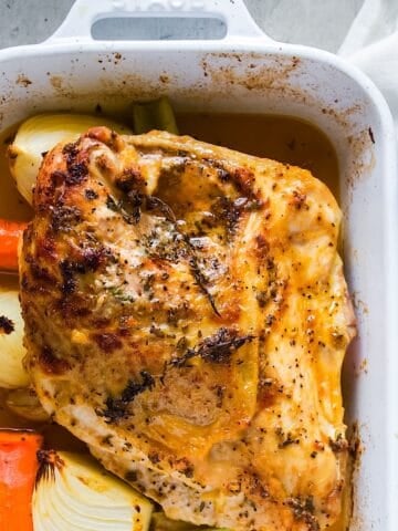 Herb roasted turkey breast in casserole dish next to linen.
