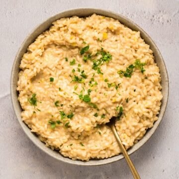 A wide shallow bowl of roasted garlic and leek risotto.