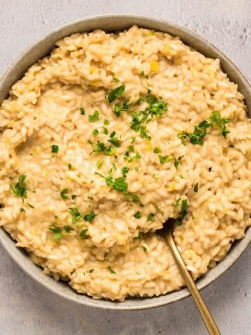 A wide shallow bowl of roasted garlic and leek risotto.