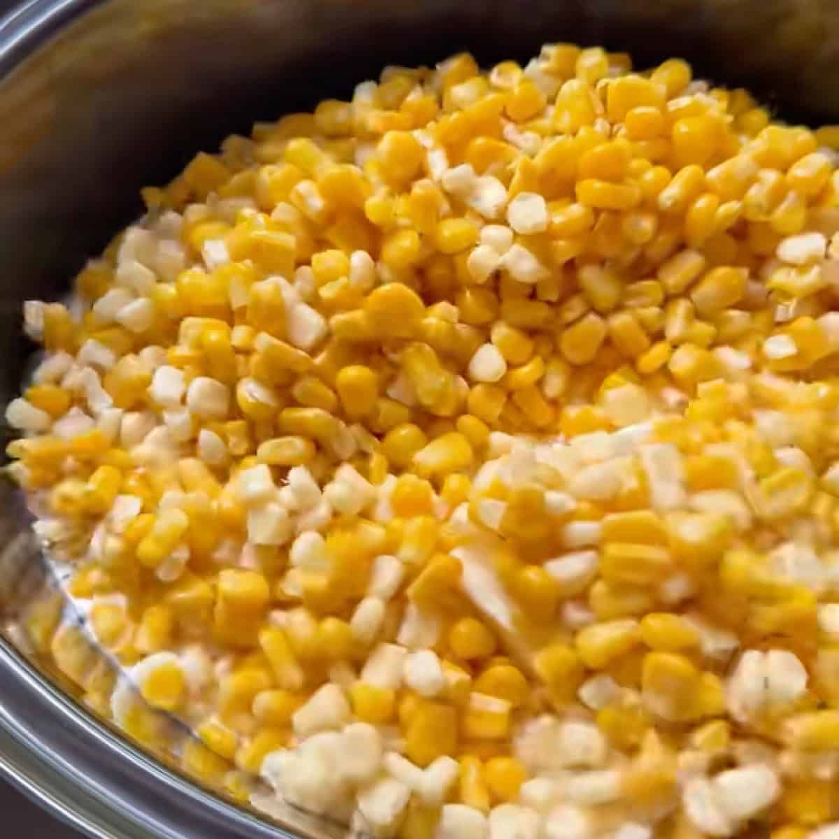 Frozen corn, butter, and cream cheese added to the slow cooker.