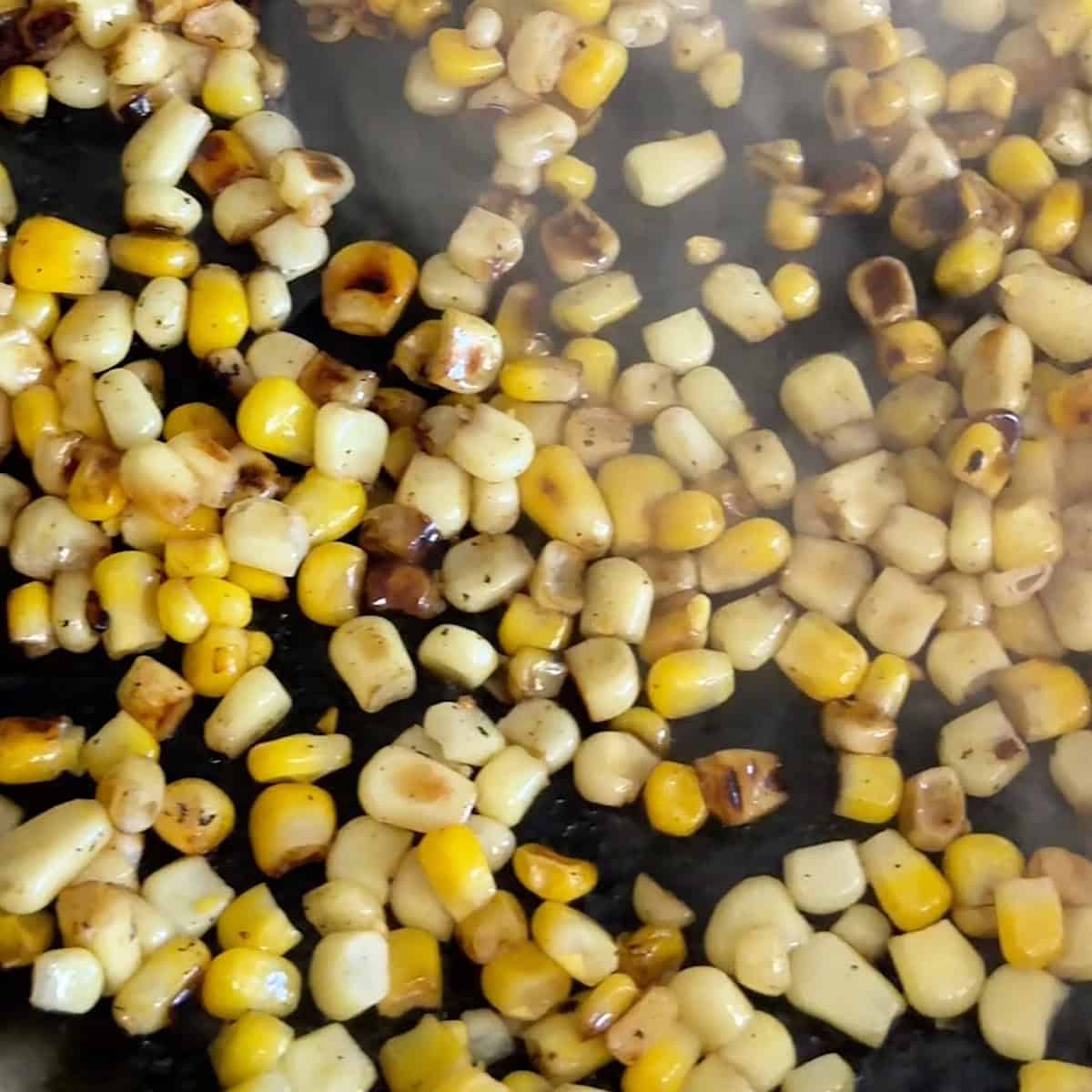 Corn cooked until charred in a skillet.