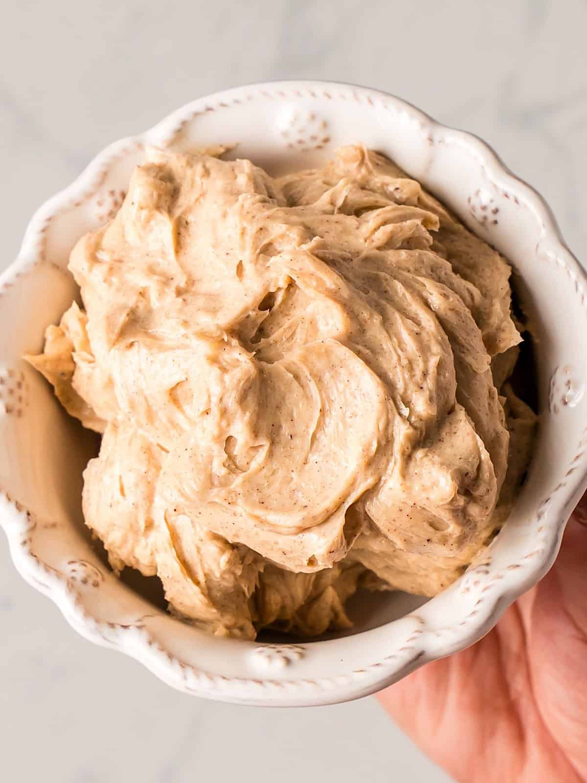 Holding fluffy whipped brown sugar cinnamon butter in a decorative bowl.