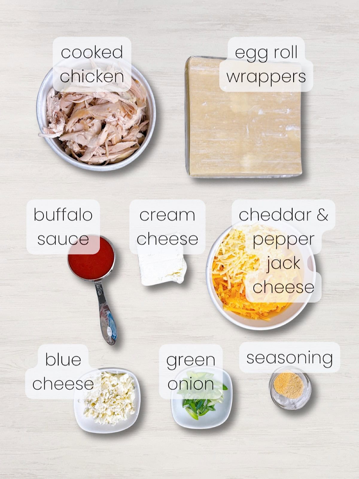 A labeled image of everything needed to make buffalo chicken egg rolls.