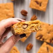Golden brown butter pecan blondies on a cooling rack with pecans.