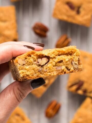 Golden brown butter pecan blondies on a cooling rack with pecans.