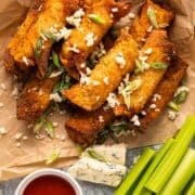 Buffalo egg rolls on a platter with blue cheese, ranch, and celery.