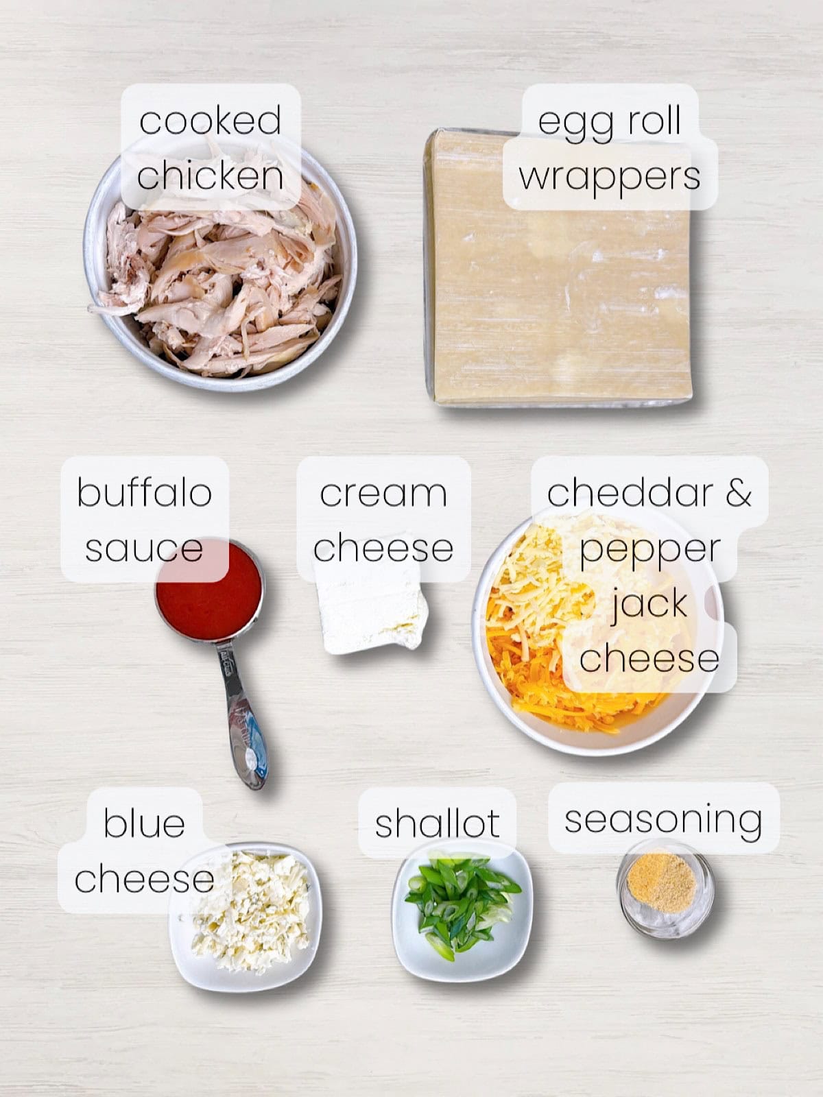 A labeled image of everything needed to make buffalo chicken egg rolls.