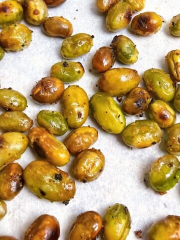 Roasted edamame on a sheet pan with parchment.