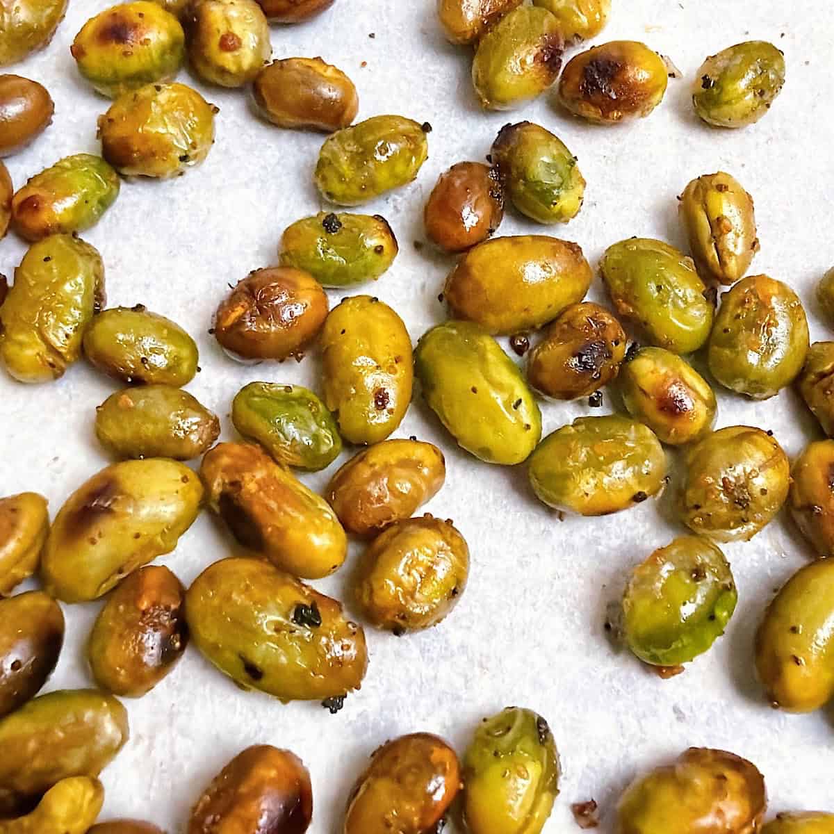 Roasted edamame on a sheet pan with parchment.