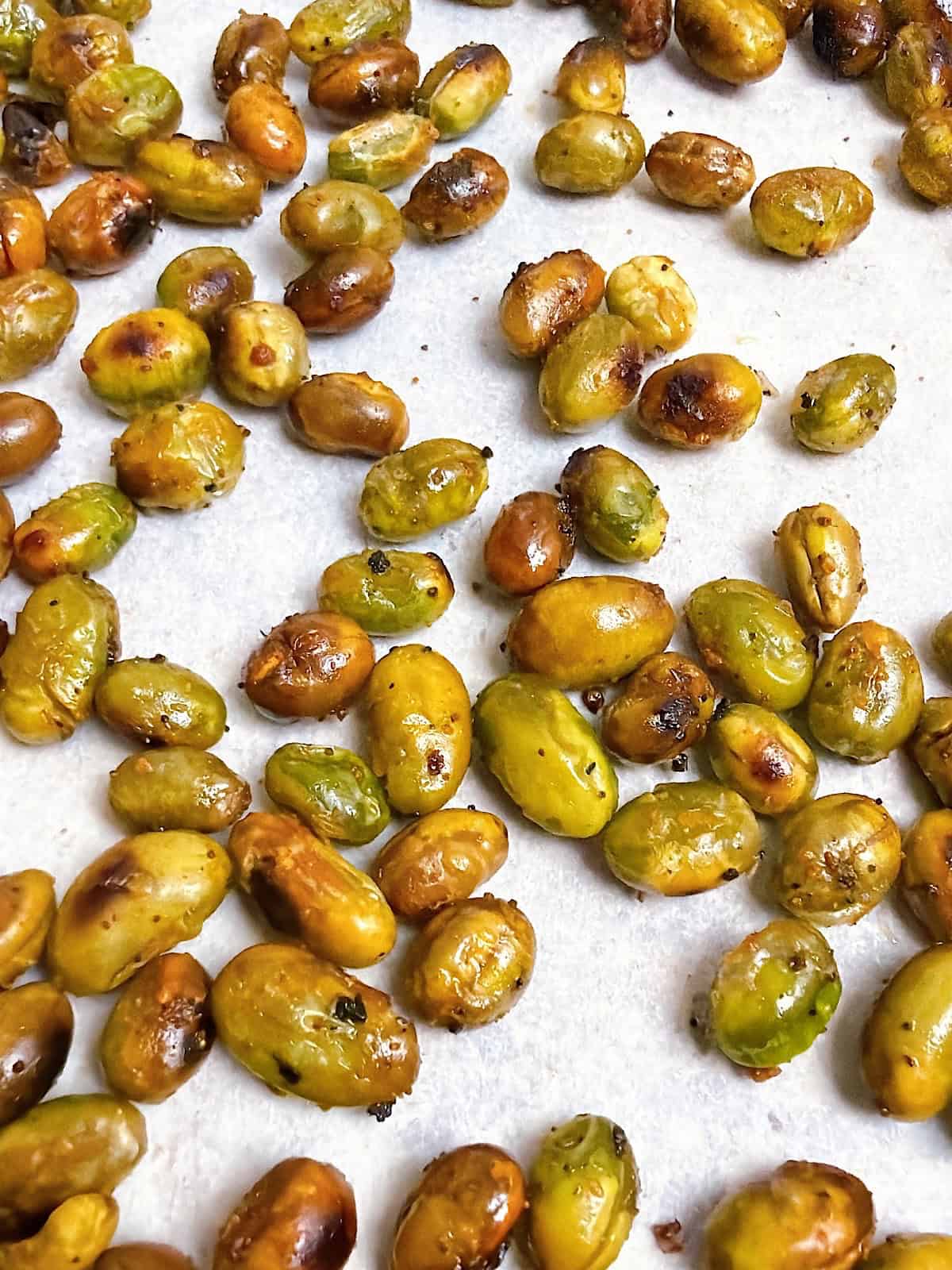 Roasted edamame on a sheet pan with parchment.