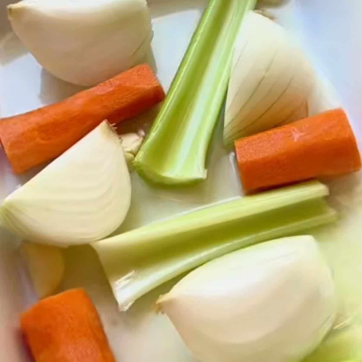 Prepared roasting pan with broth and vegetables.