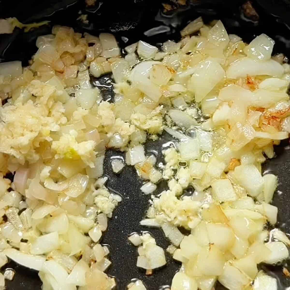 Onions softening in a pan with minced garlic.