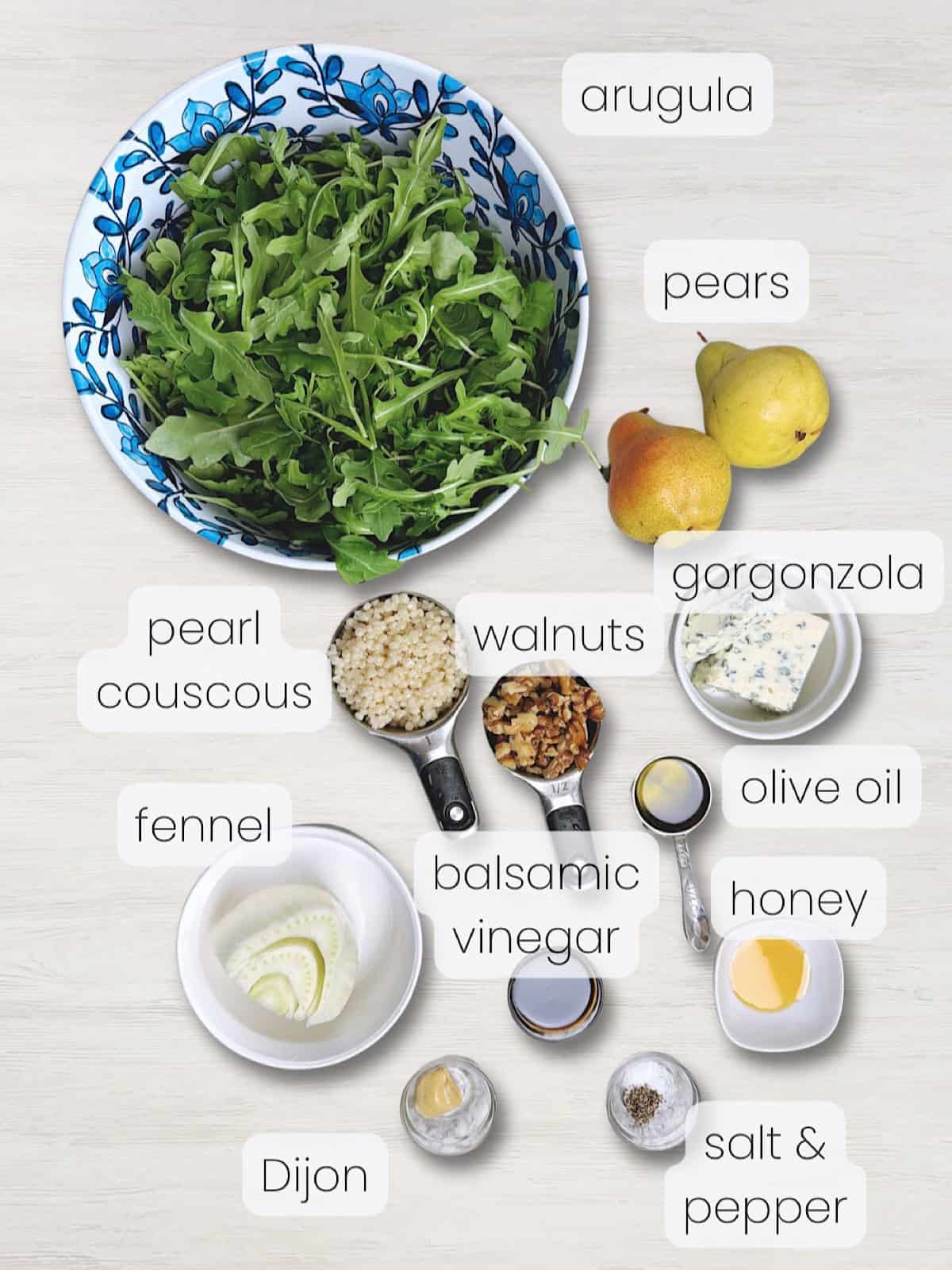 A labeled image of everything needed to make a pear arugula salad with Gorgonzola, fennel, and walnuts.