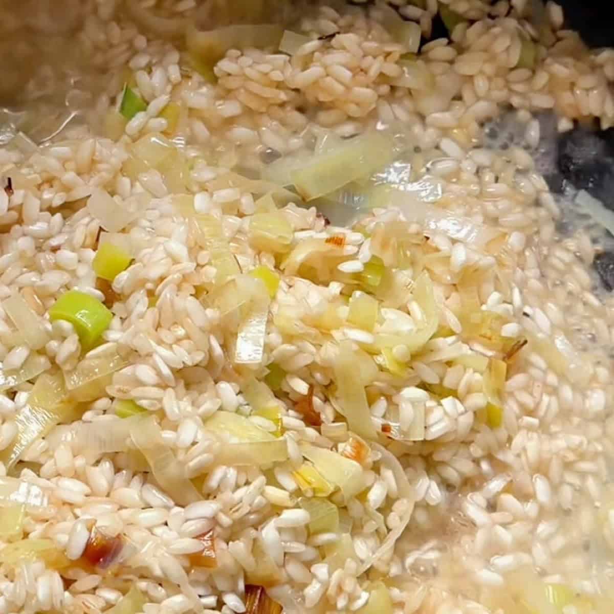 A ladle of stock added to the risotto.