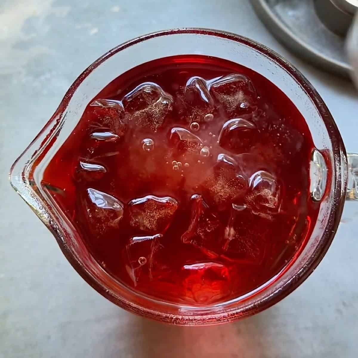 Grenadine poured into the pitcher of ginger ale.