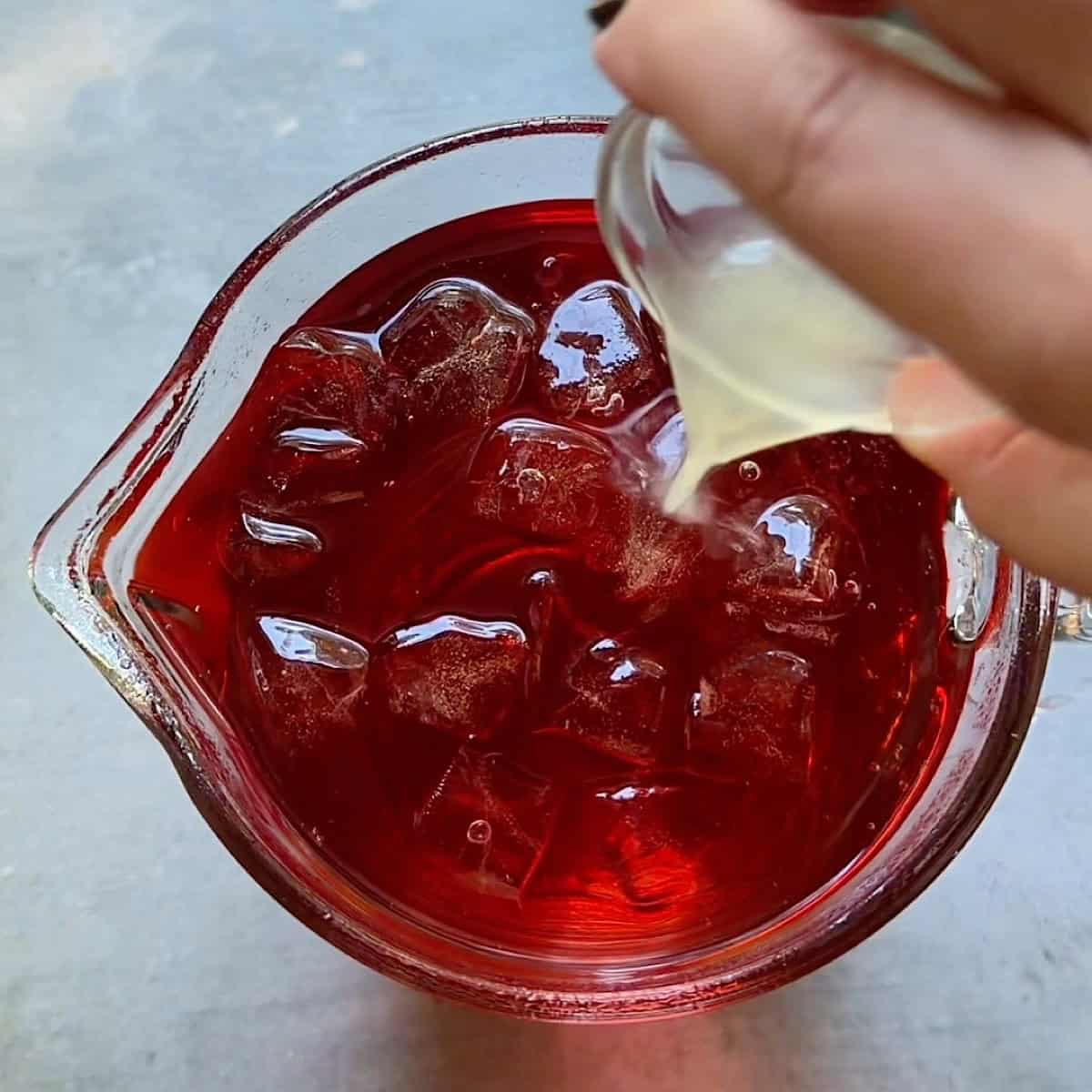 Adding the fresh lime juice to the pitcher.