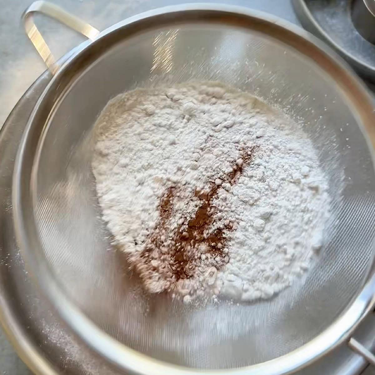 Sifting the dry ingredients in a mixing bowl.